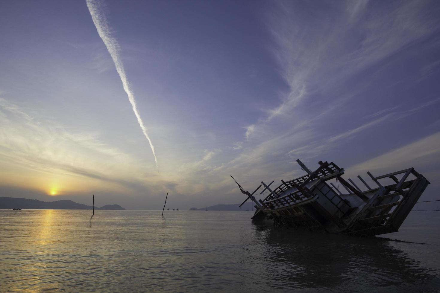 Sinking boat, view at sunrise photo