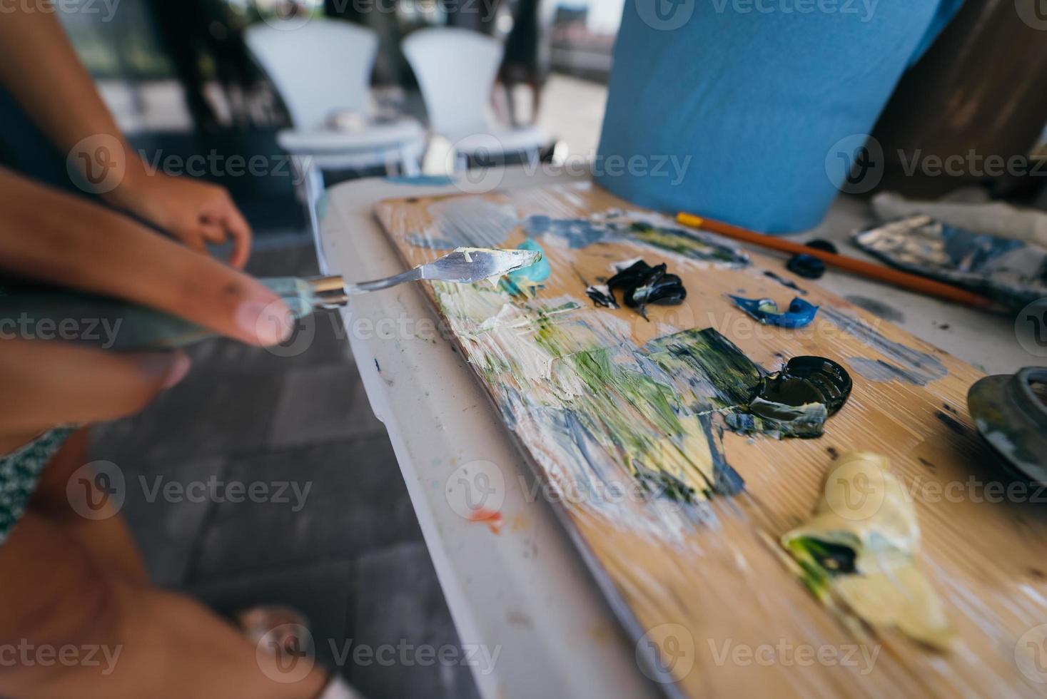 Close up of woman's hand mix paints in palette photo