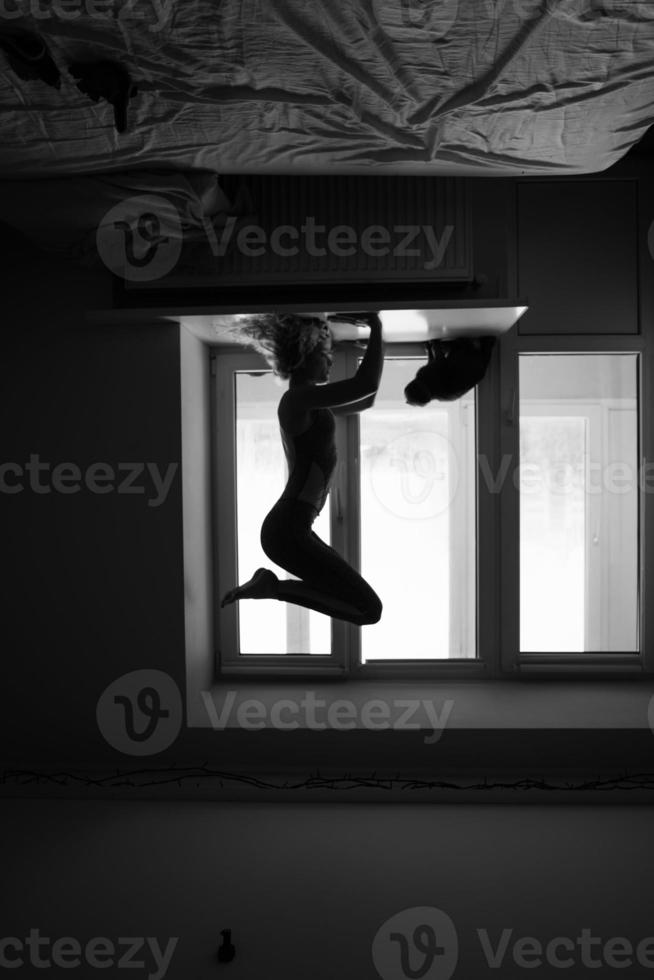 woman doing yoga asana on window sill photo