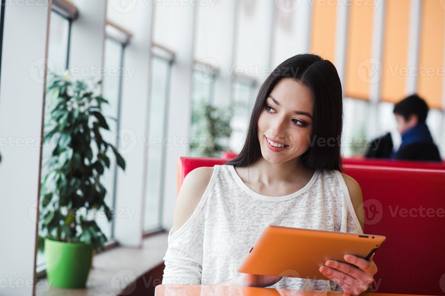 Beautiful girl working on a tablet and smiling photo