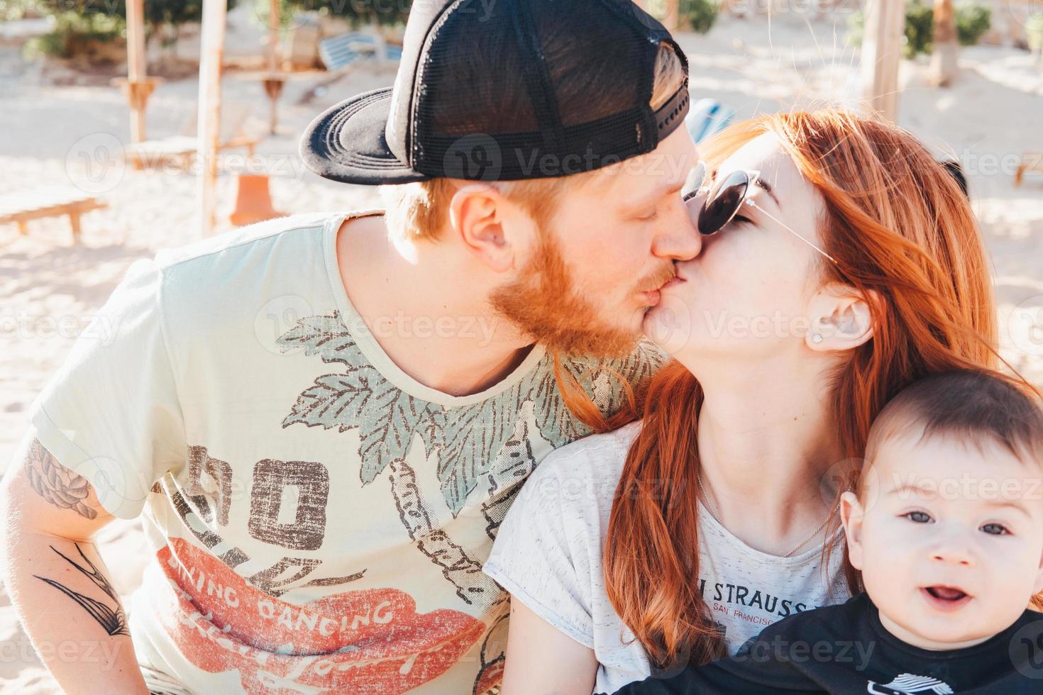 Parents spend time with their son on the beach photo