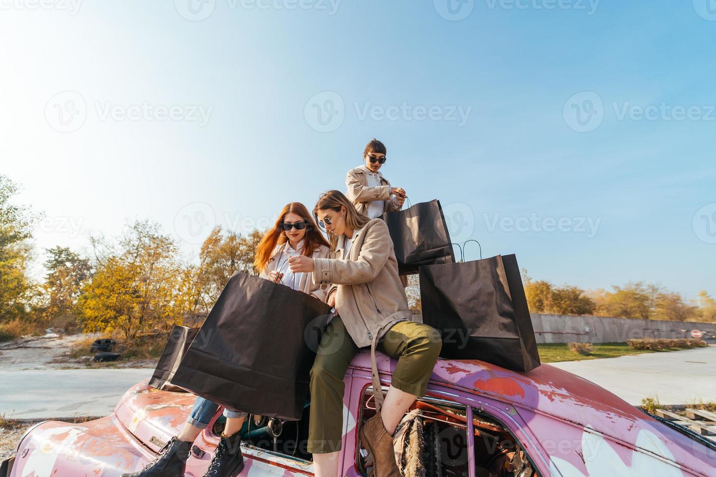 Young women posing on the old decorated car photo