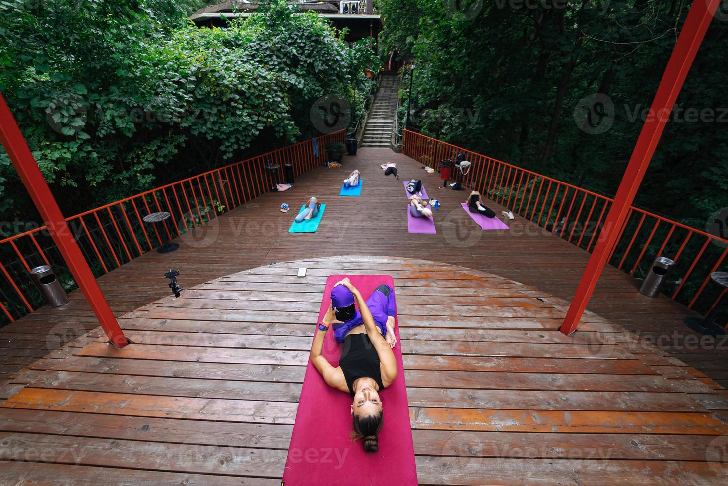 Group of young sporty people practicing yoga lesson with instructor, photo