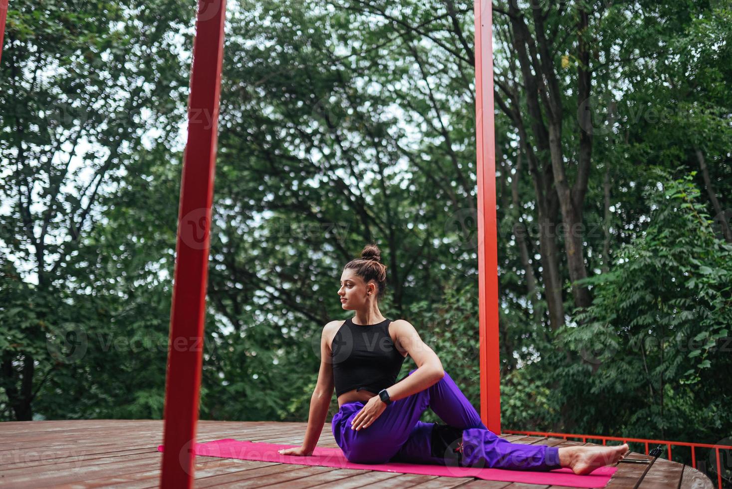 mujer fitness sentada en una alfombra haciendo yoga foto
