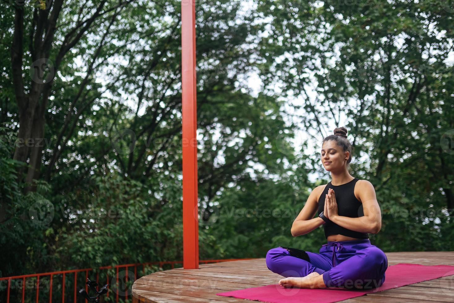 Young woman is practising yoga sitting in the lotus position photo