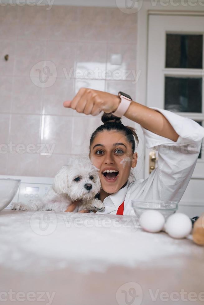 Woman is playing with a dog while pouring flour photo