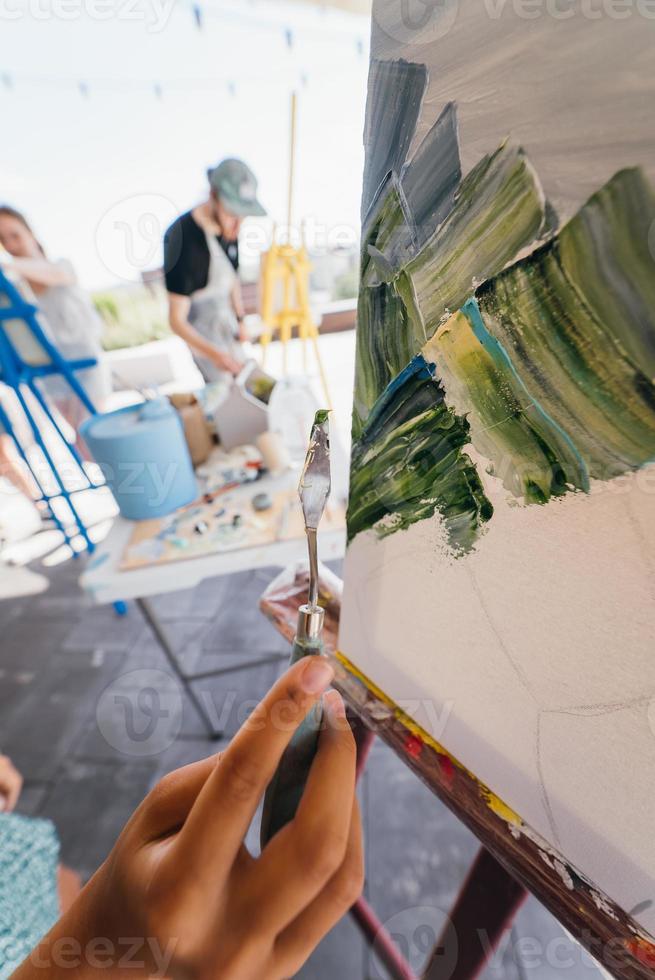 Close-up of woman's hand applying paint to a canvas photo