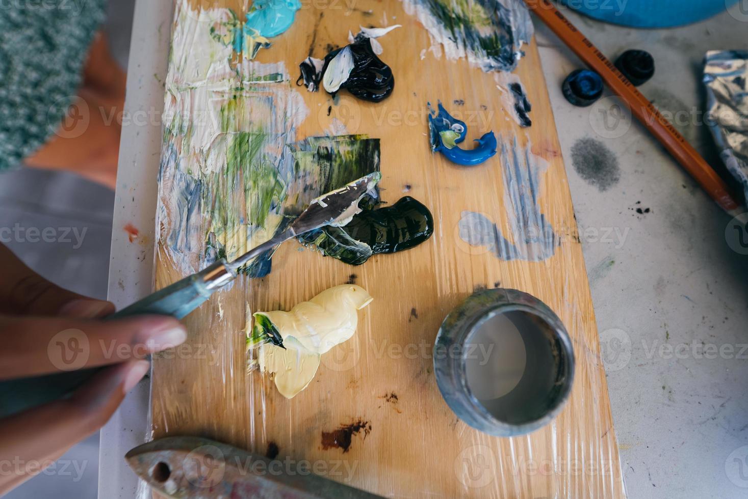 Close up of woman's hand mix paints in palette photo