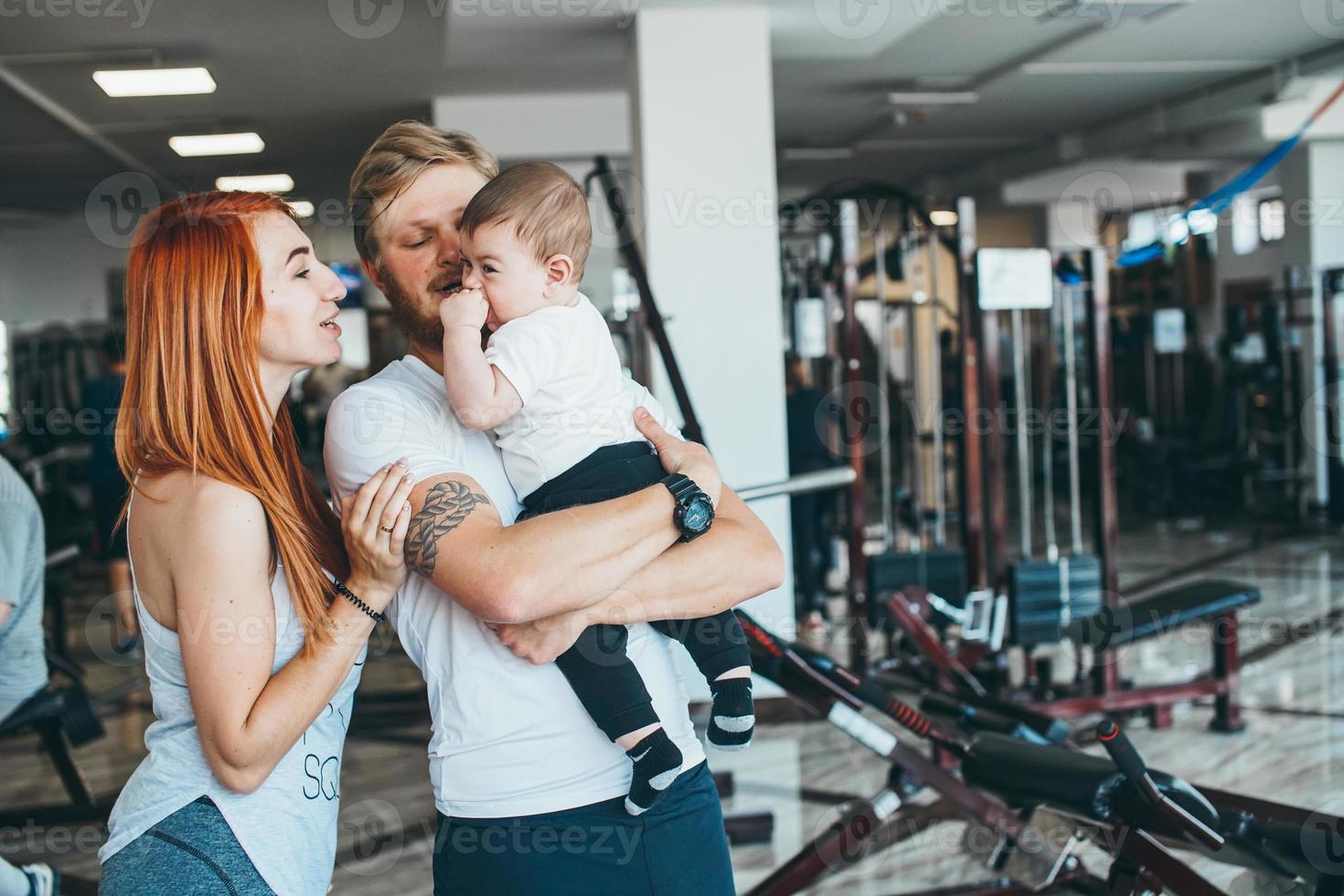 familia joven con niño pequeño en el gimnasio foto