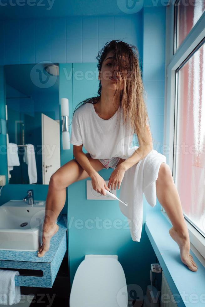 Beautiful, young woman in the bathroom is having fun photo