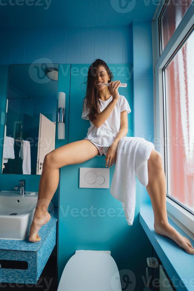 Young beautiful woman brushing her teeth with toothbrush photo