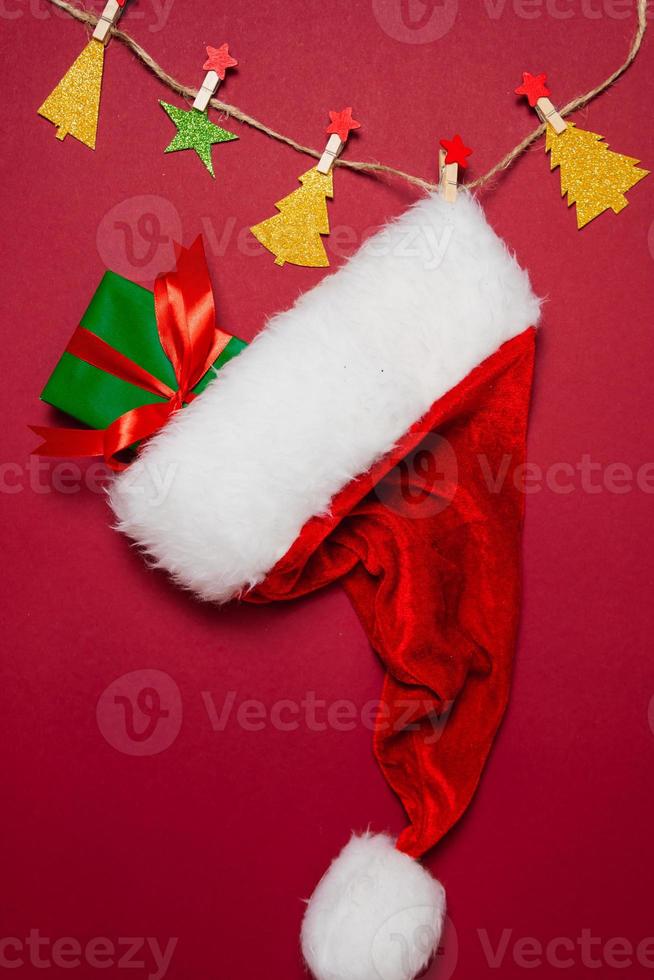 New Year and Christmas decorations on red background, flat lay. Concept of greeting card for holidays photo