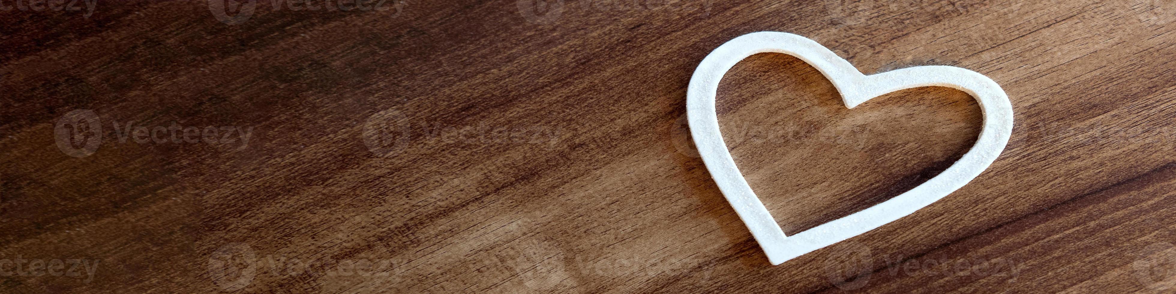 white heart against a wooden background. banners for Valentine's Day photo