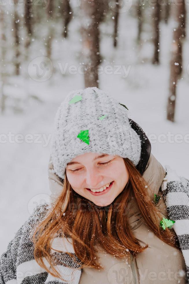 Green confetti tree on girl hat. Portrait of a girl in a grey hat with confetti in winter photo