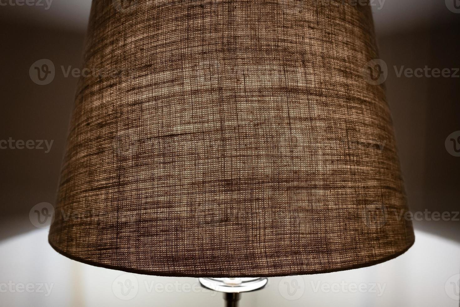 Beige shade of the floor lamp dims the light and creates a calm atmosphere in the bedroom. photo