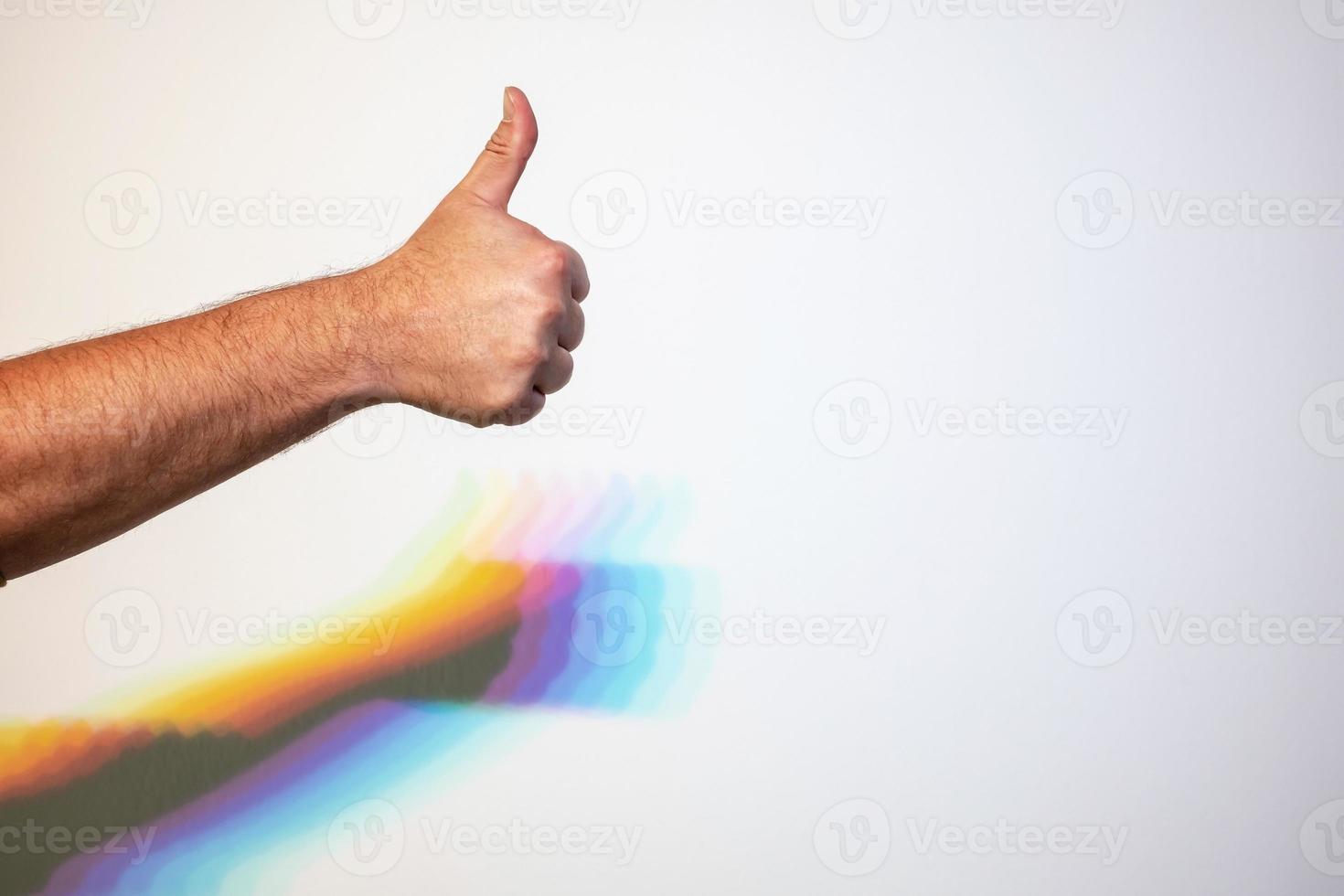 pulgar hacia arriba, signo de aprobación y sombra de mano de arco iris sobre fondo blanco. copie el espacio. foto