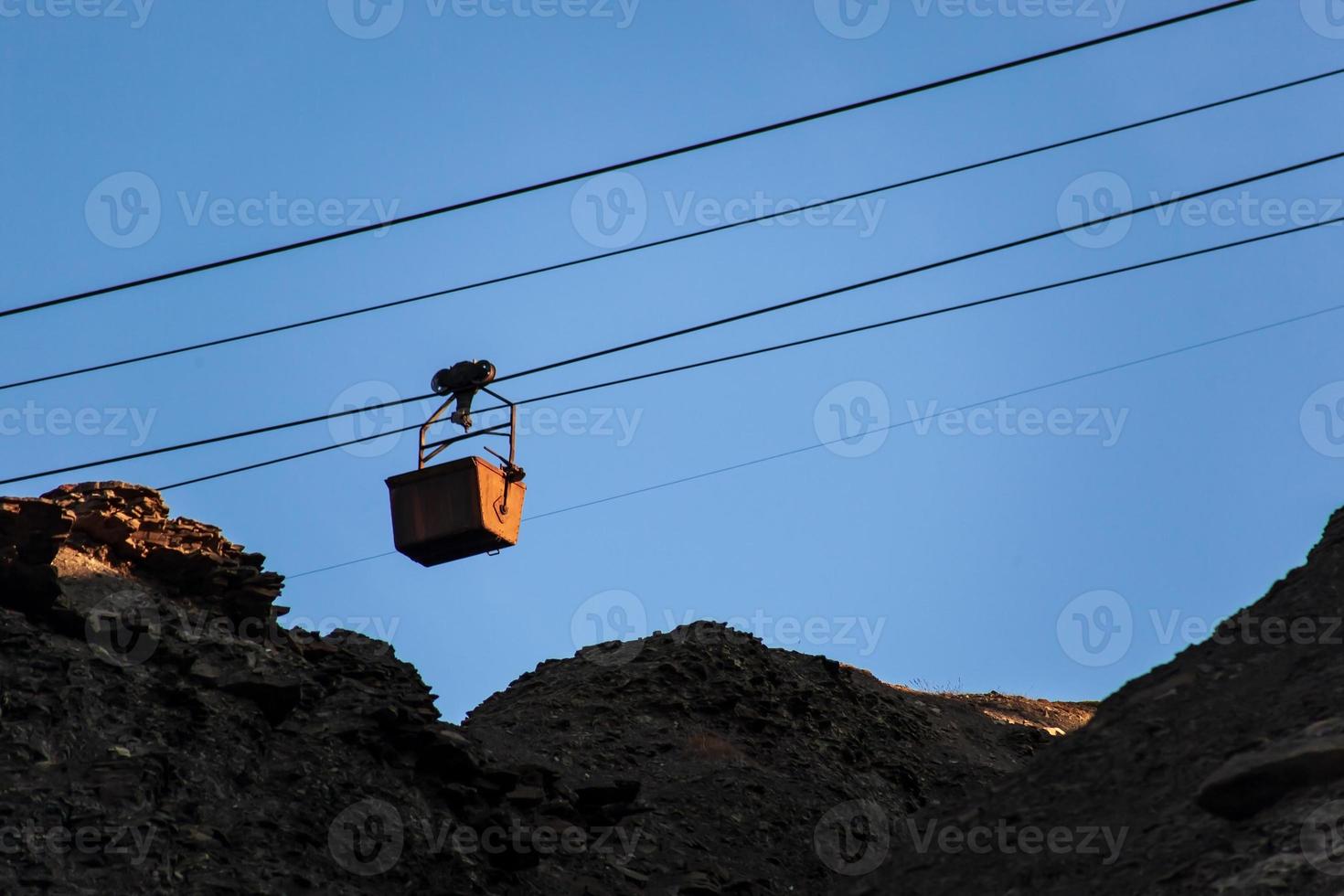 Silhouette of an old cable car and trolley for coal mining, at sunset, against a sky. Energy crisis concept. photo