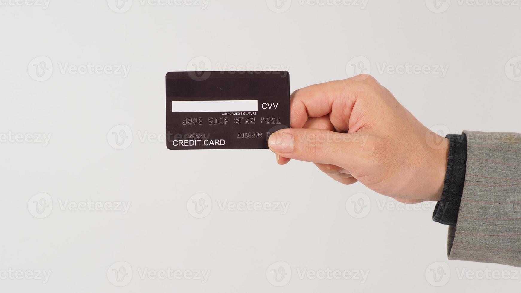 A hand is holding back of black credit cards and wearing a suit on white background. photo