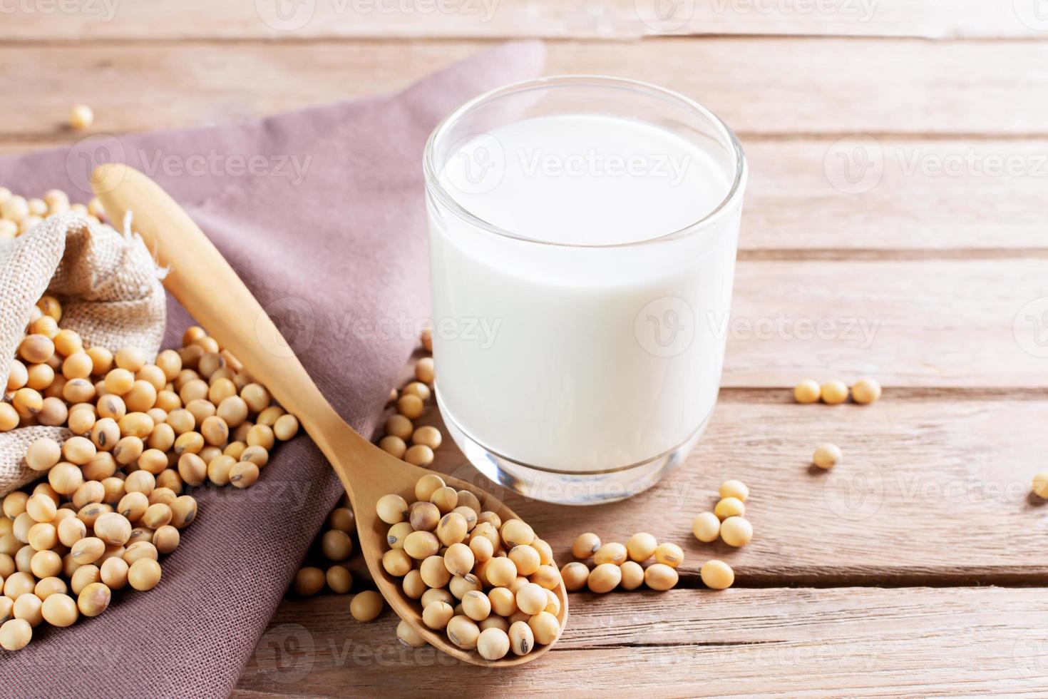 leche de soja en un vaso con soja en una mesa de madera desayuno orgánico, alto en proteínas, productos agrícolas saludables, vegetariano foto