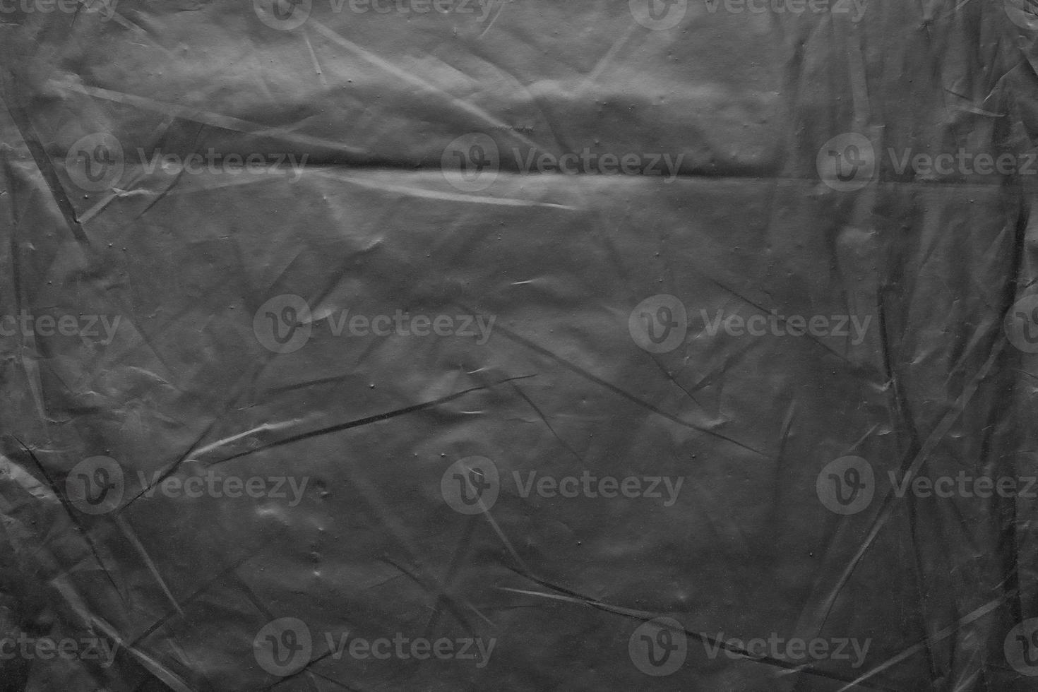 transparent plastic bag wrap overlay texture on black background photo