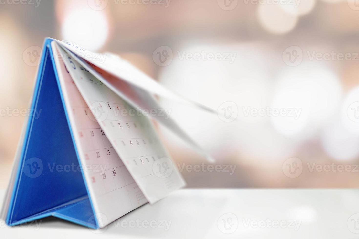 desk calendar on table with blurred bokeh background appointment and business meeting concept photo