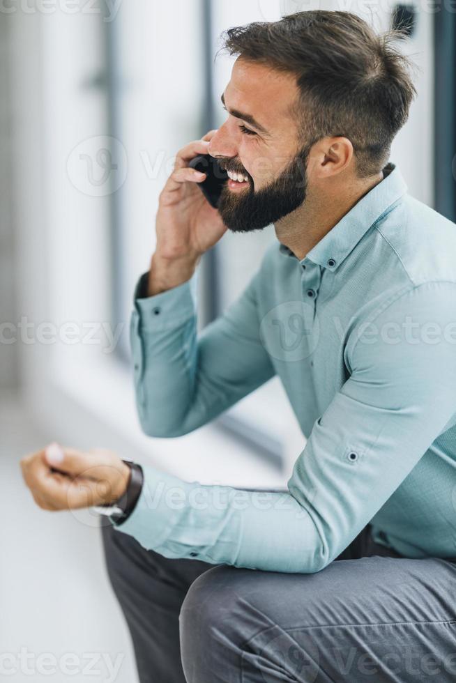 A Business Man Talking On A Smartphone On A Break At The Office Hall photo