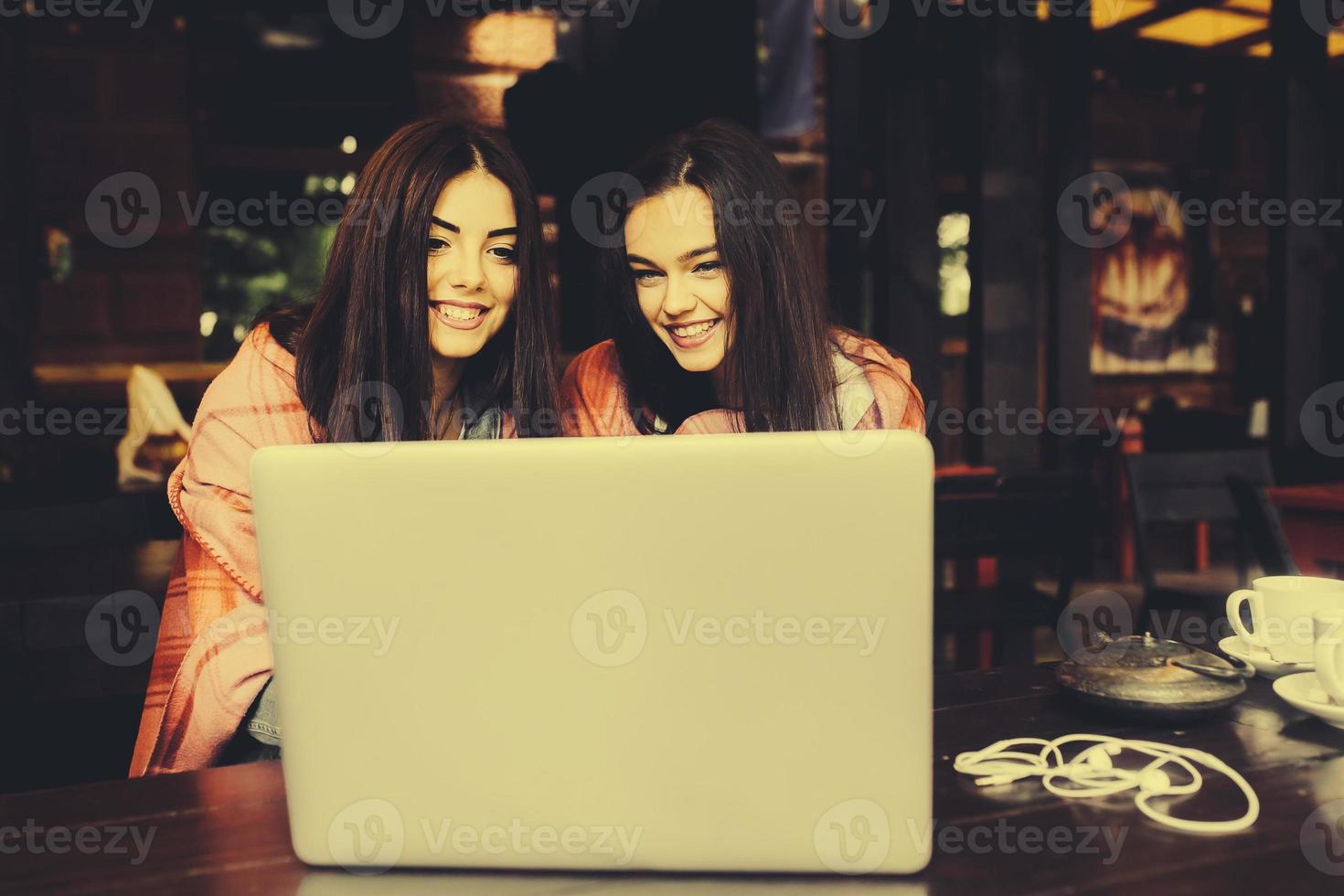 two girls watching something in laptop photo