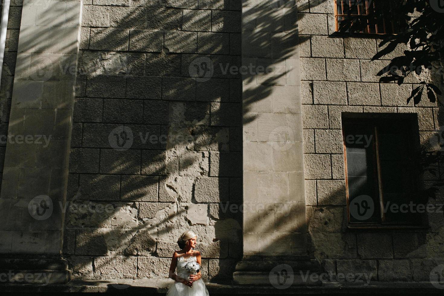 bride posing on stone wall background photo