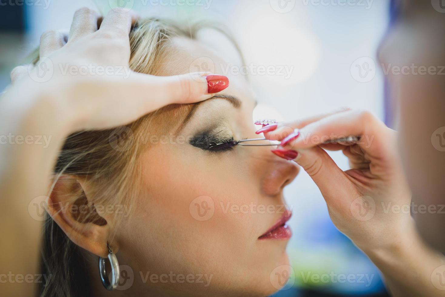 Makeup Artist Applying Eyeshadow On A Girl photo