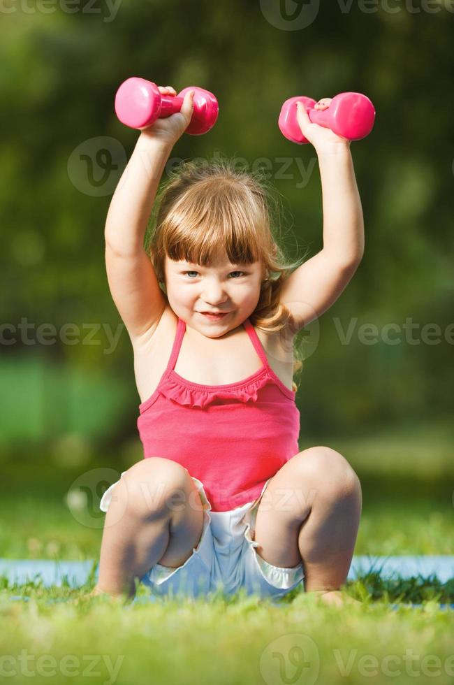 Little girl with dumbbells photo