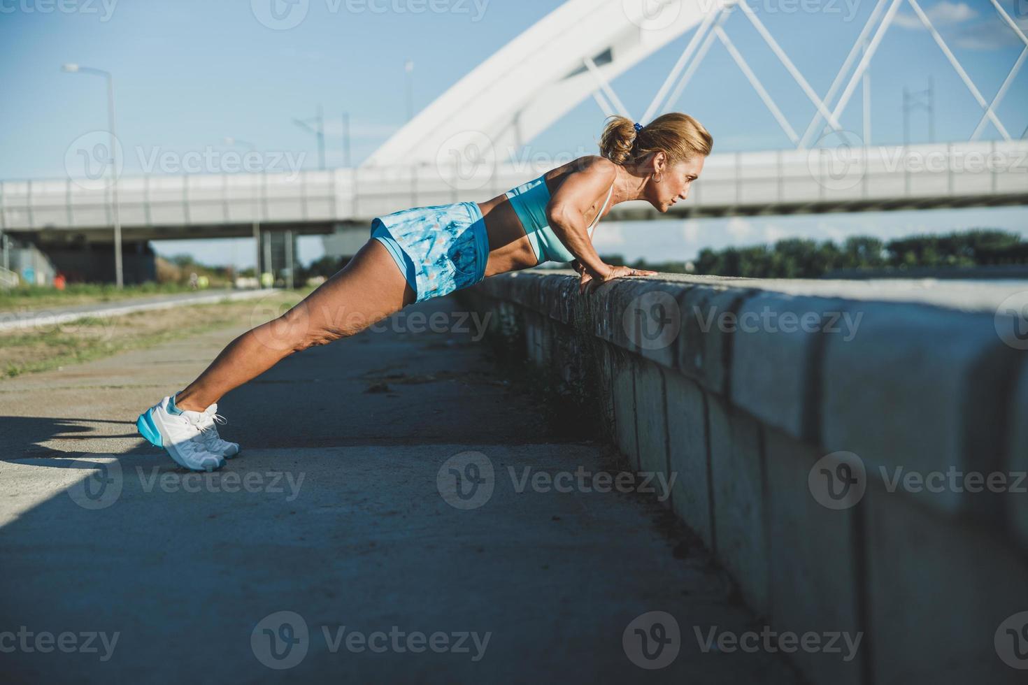 Fit Woman Practicing Push-ups During Outdoors Workout photo