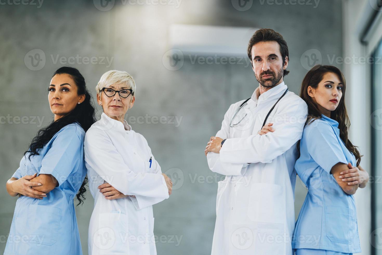 Team Of Doctors And Nurses Standing With Arms Crossed And Looks At Camera photo