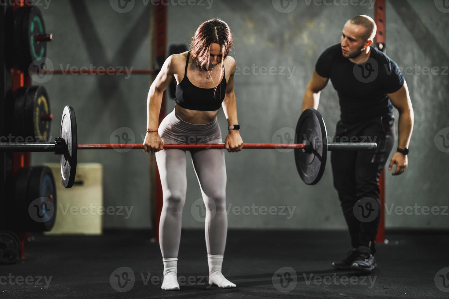 Woman Exercising With Personal Trainer At The Gym photo