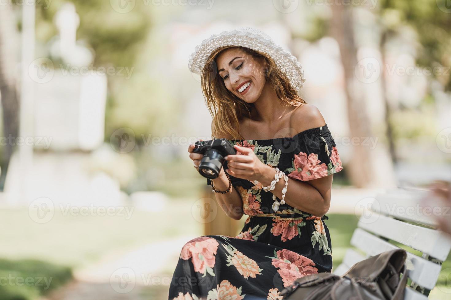 Woman Looking Photos On A Digital Camera While Enjoying Spending Time In The Park