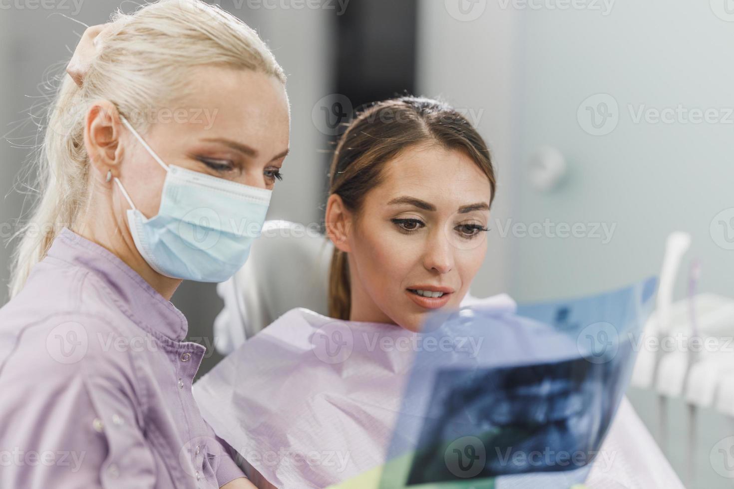 Dentist Explaining Tooth X-Rays To A Patient photo