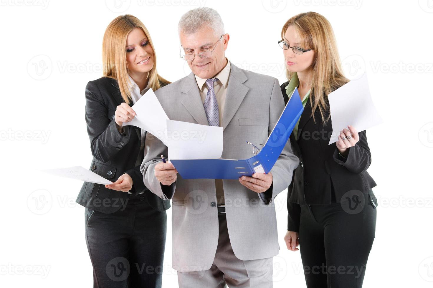 Three smiling business people looking at documents photo