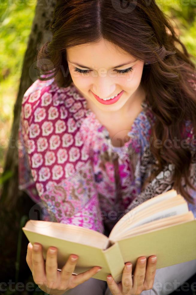 niña con un libro en el parque foto