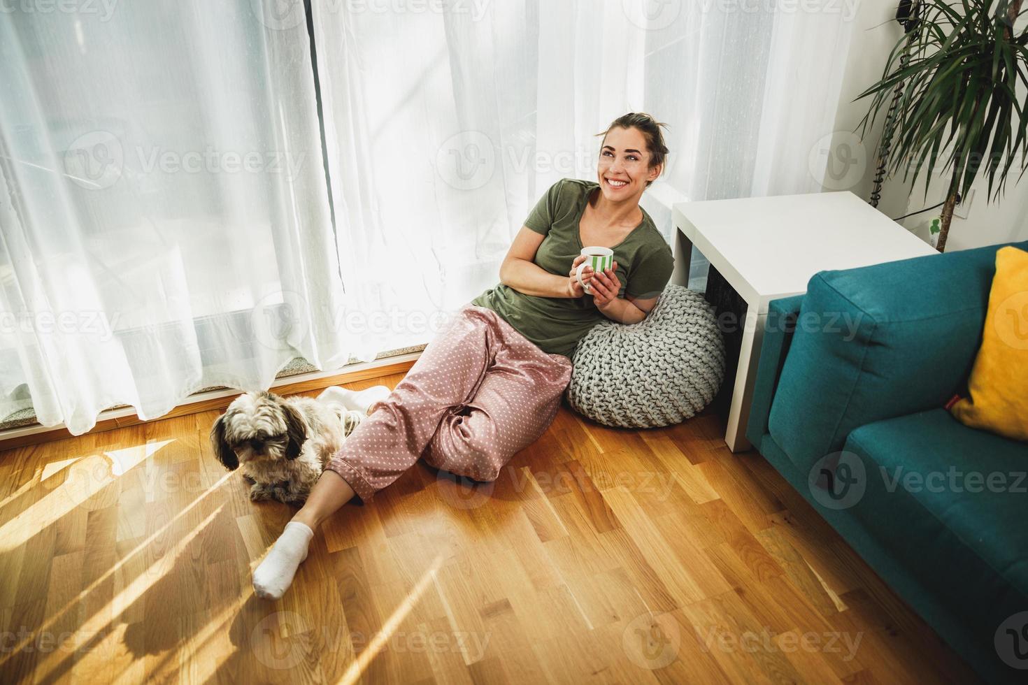 Woman Enjoying Coffee At Morning Sunshine With Her Small Dog photo