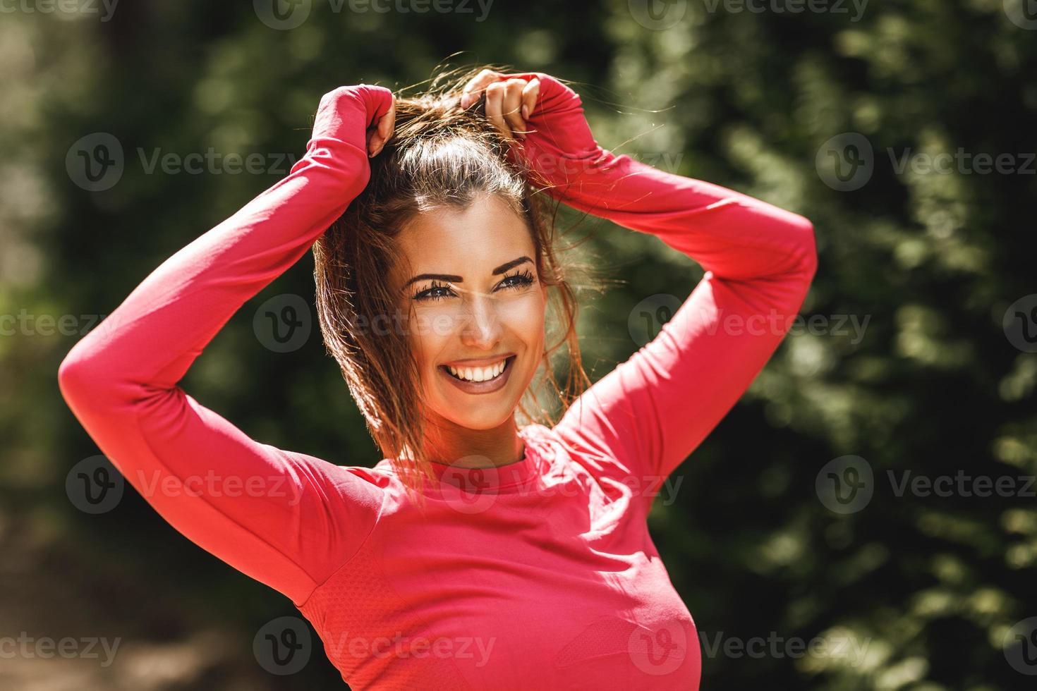 Woman Tying Her Hair Before Training Outdoors photo