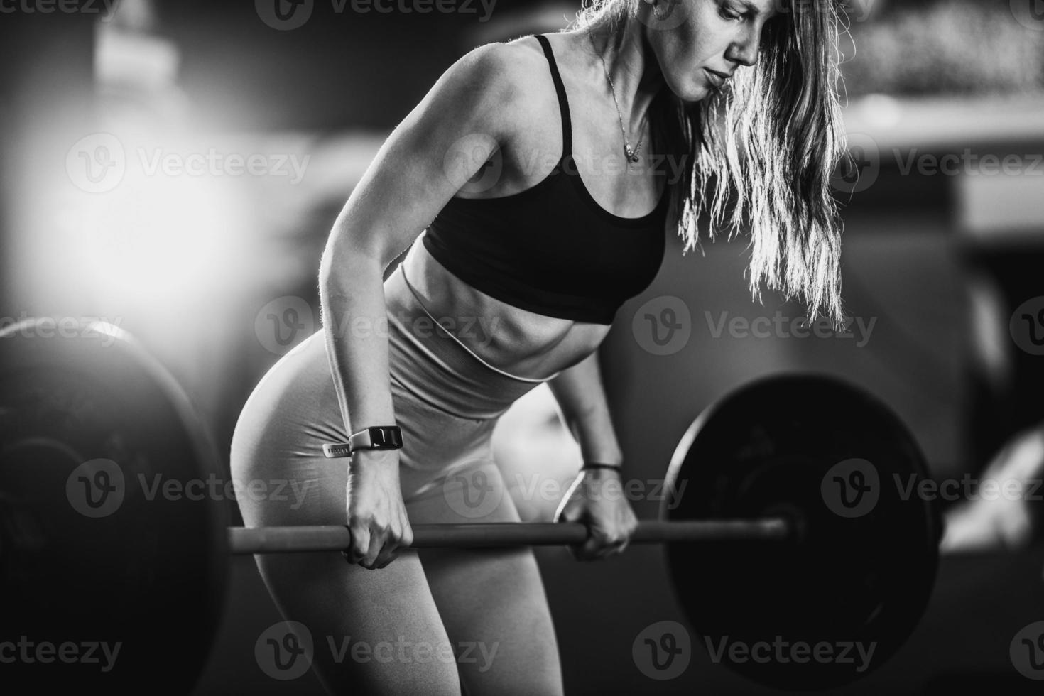 Muscular Woman Doing Back Training With Barbell At The Gym photo