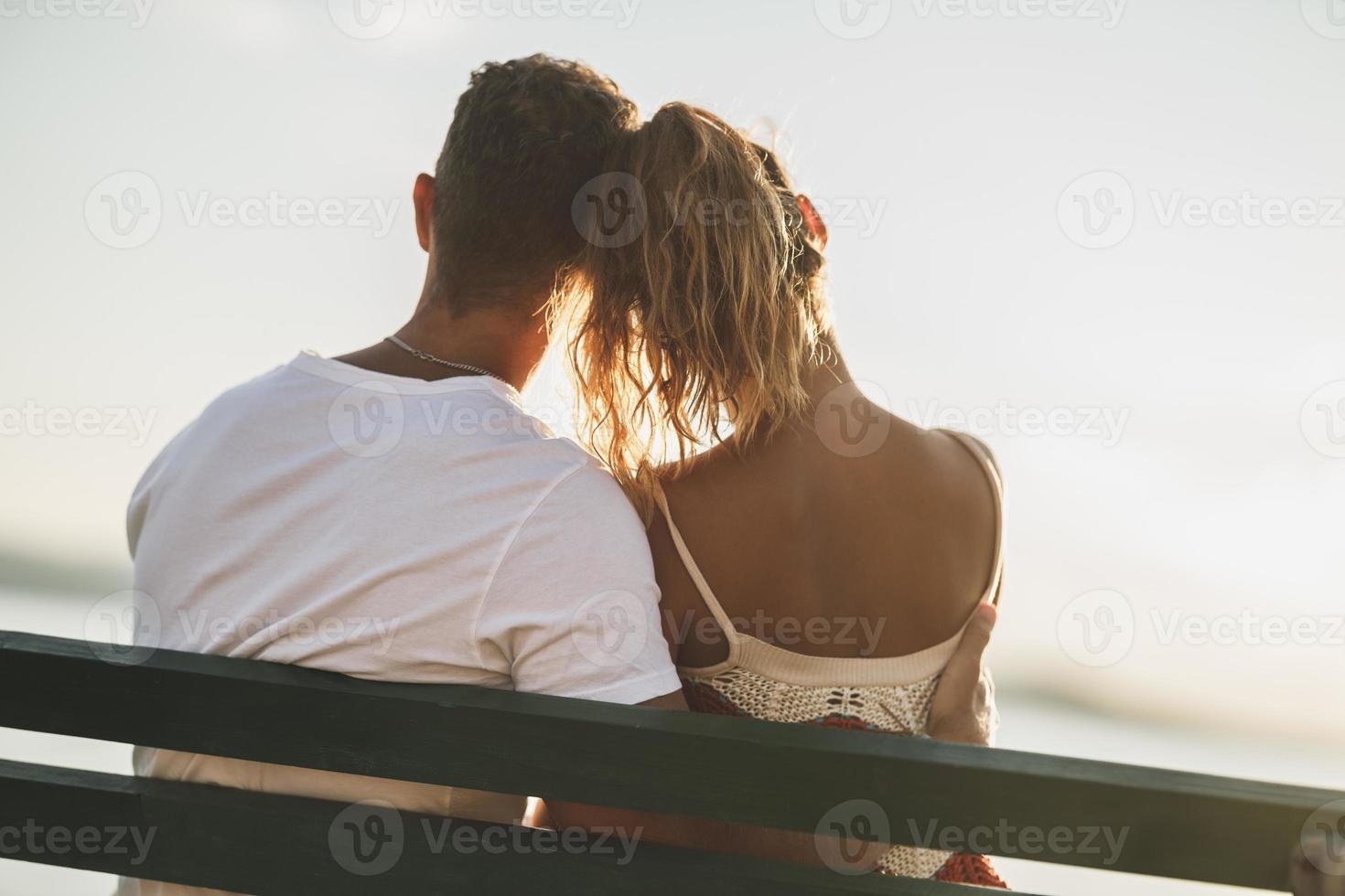 Couple Sitting On Bench And Enjoying Time On A Vacation Near The Beach photo