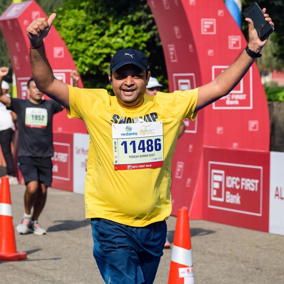 New Delhi, India - October 16 2022 - Vedanta Delhi Half Marathon race after covid in which marathon participants about to cross the finish line, Delhi Half Marathon 2022 photo