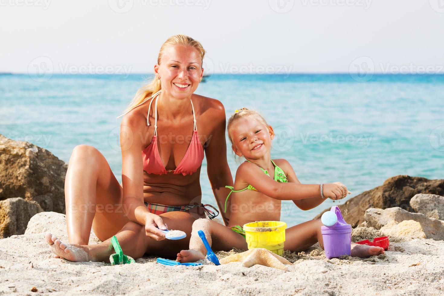 niña con madre en la playa foto