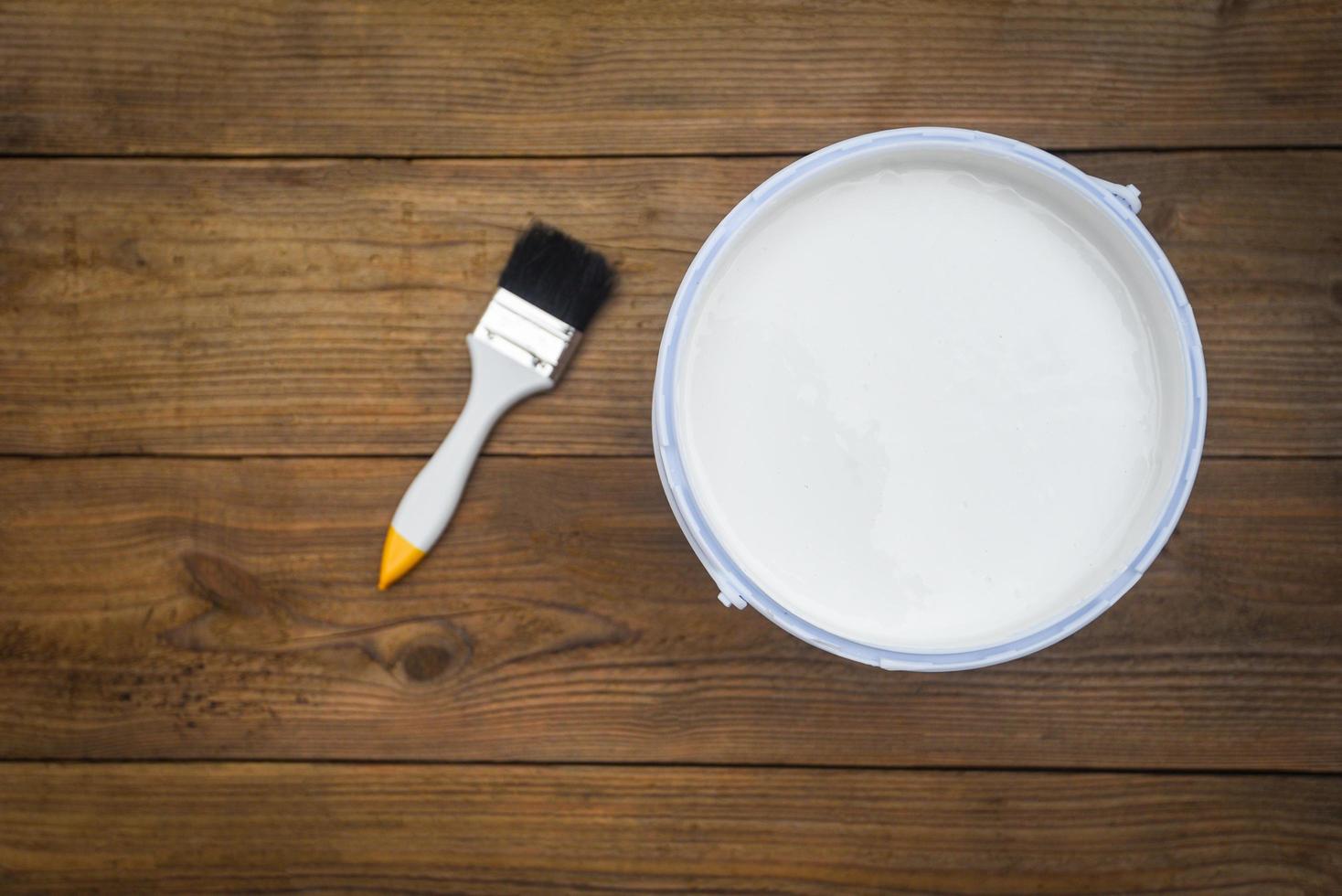 Painted tool with paint brush paint bucket canned paint for painting on wooden background, top view photo