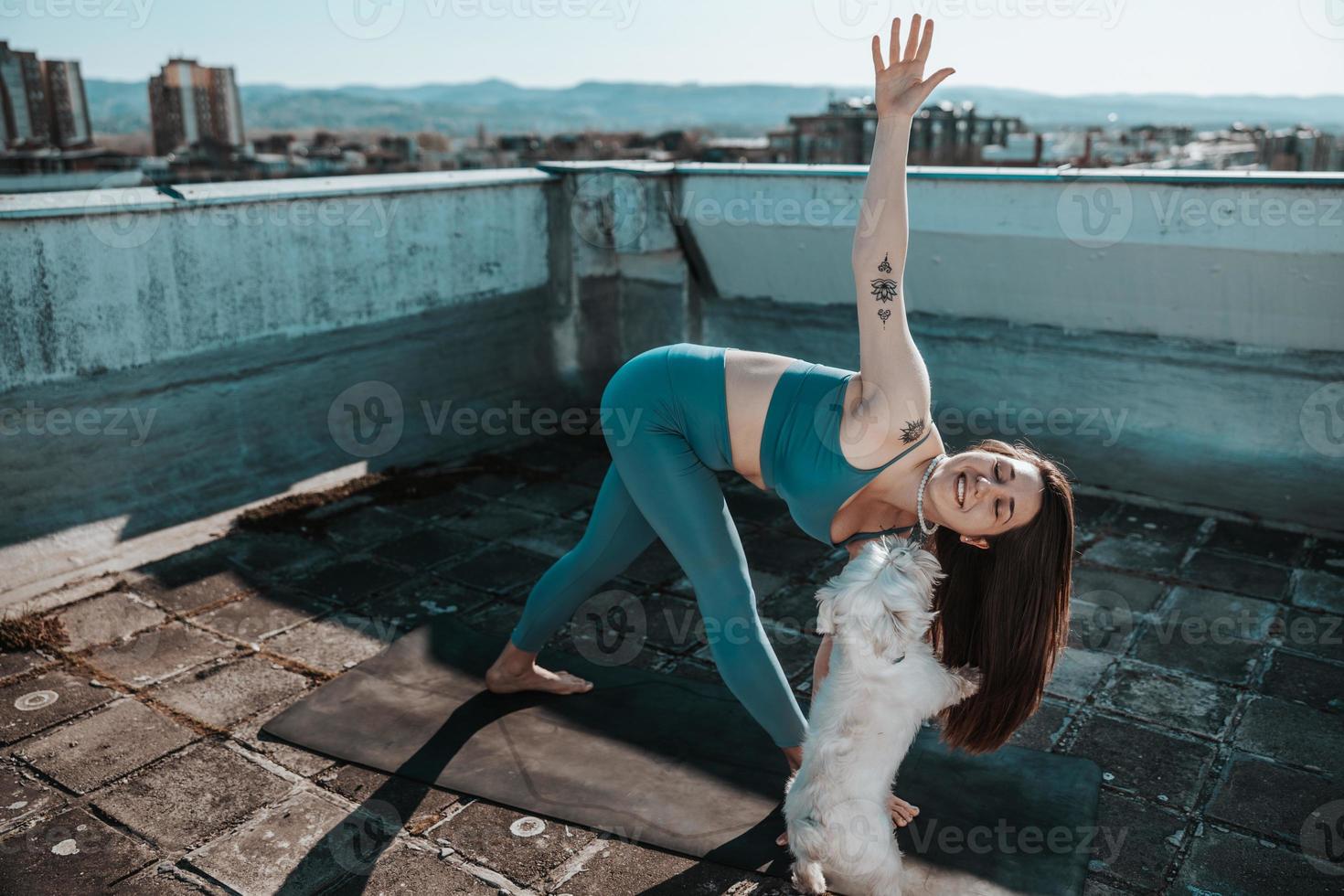 Woman Doing Yoga Outdoors On A Rooftop Terrace photo