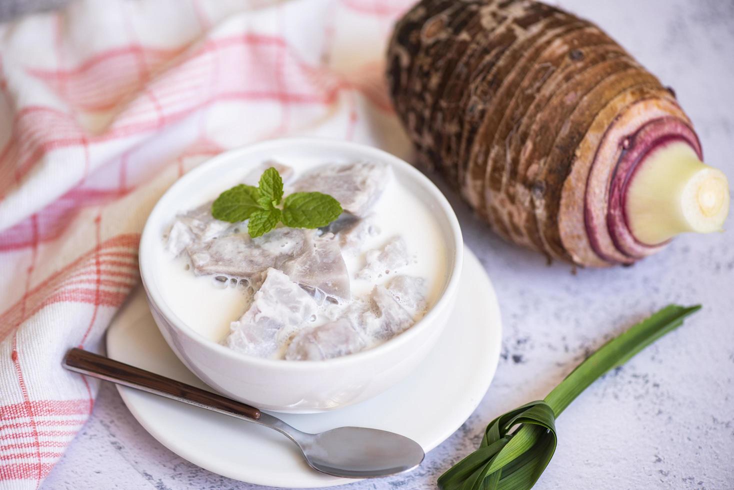 Taro food with dessert taro boiled with sugar and coconut milk on bowl and fresh raw organic taro root ready to cook, Asian Thai food photo