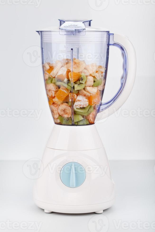 Blender filled with fresh fruit photo