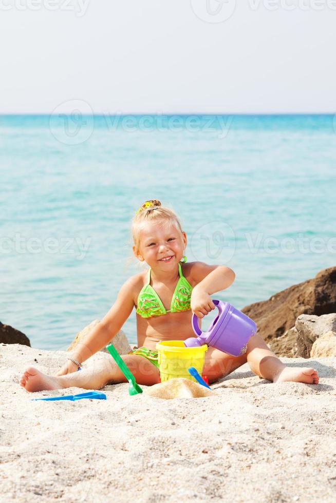 niña jugando en la playa foto