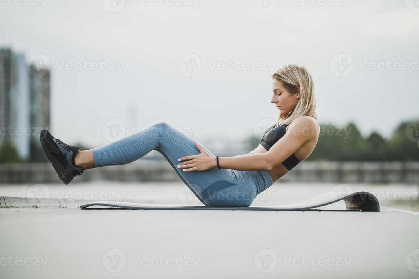 Young Fit Woman Doing Sit Ups While Doing Outdoors Training photo