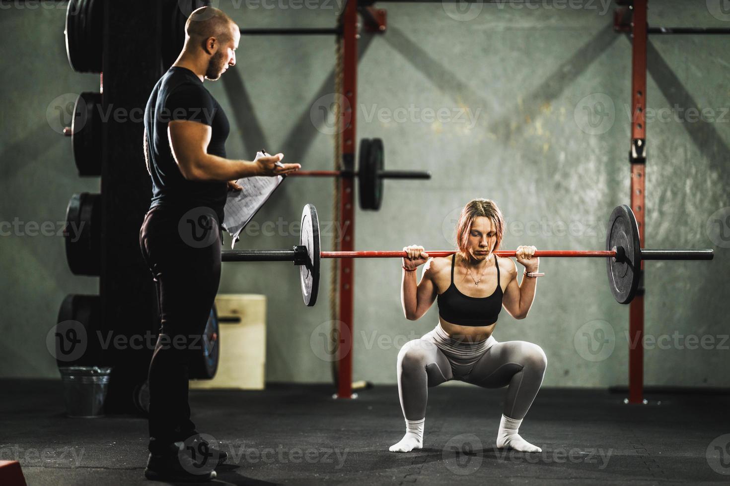 Woman Doing Hard Training With Coach At The Gym photo